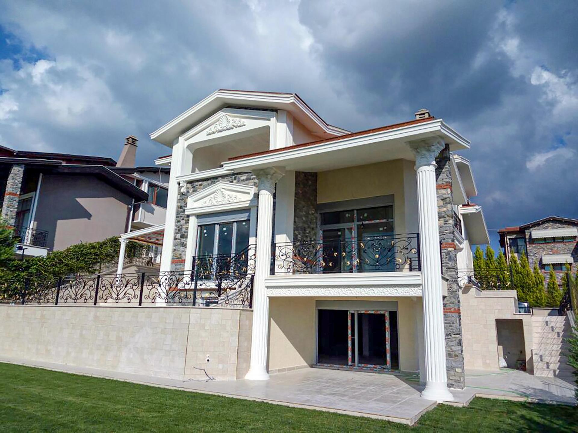 Taş kaplama villa dış cephesinde kullanılan beyaz poliüretan sütunlar, pencere söveleri ve alttan görünümü.