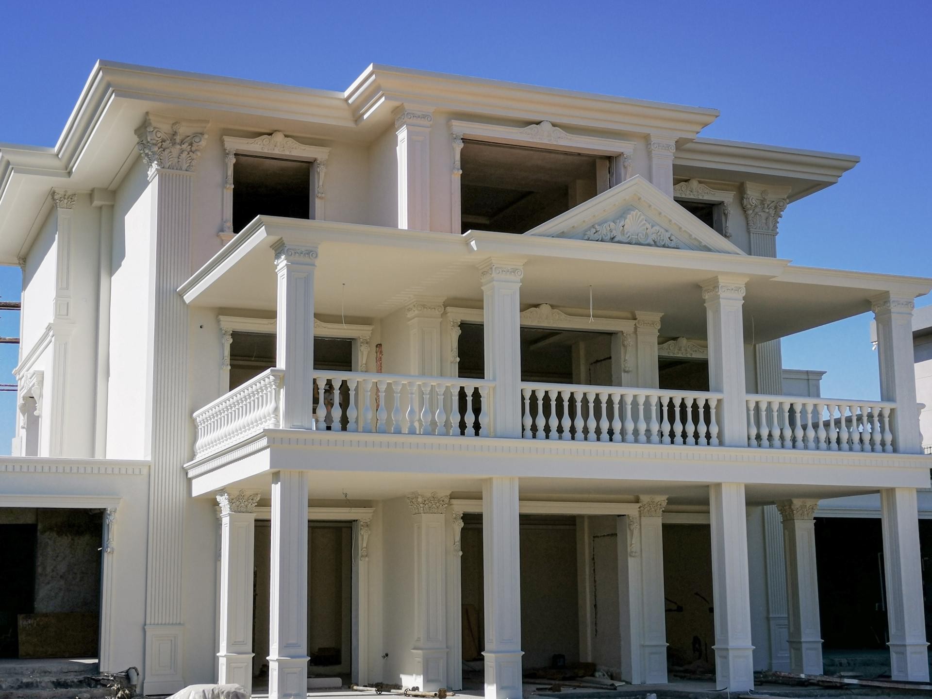 Poliüretan söve, pilaster sütun ve taç modelleriyle kaplanmış iki katlı beyaz villa dış cephe tasarımı.