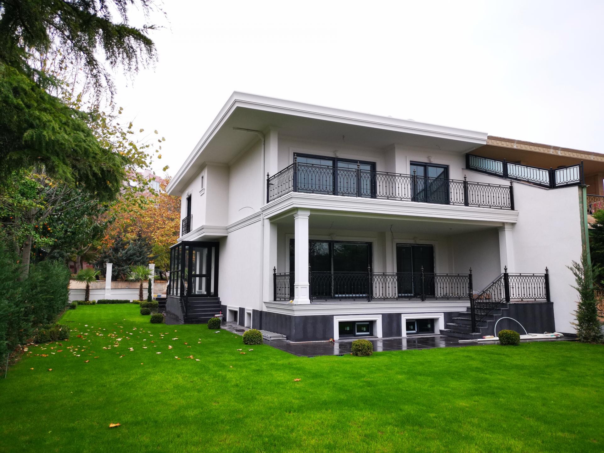 İki katlı modern beyaz villanın dış cephesinde kullanılan poliüretan söve ve pilaster sütun kaplama detayları.
