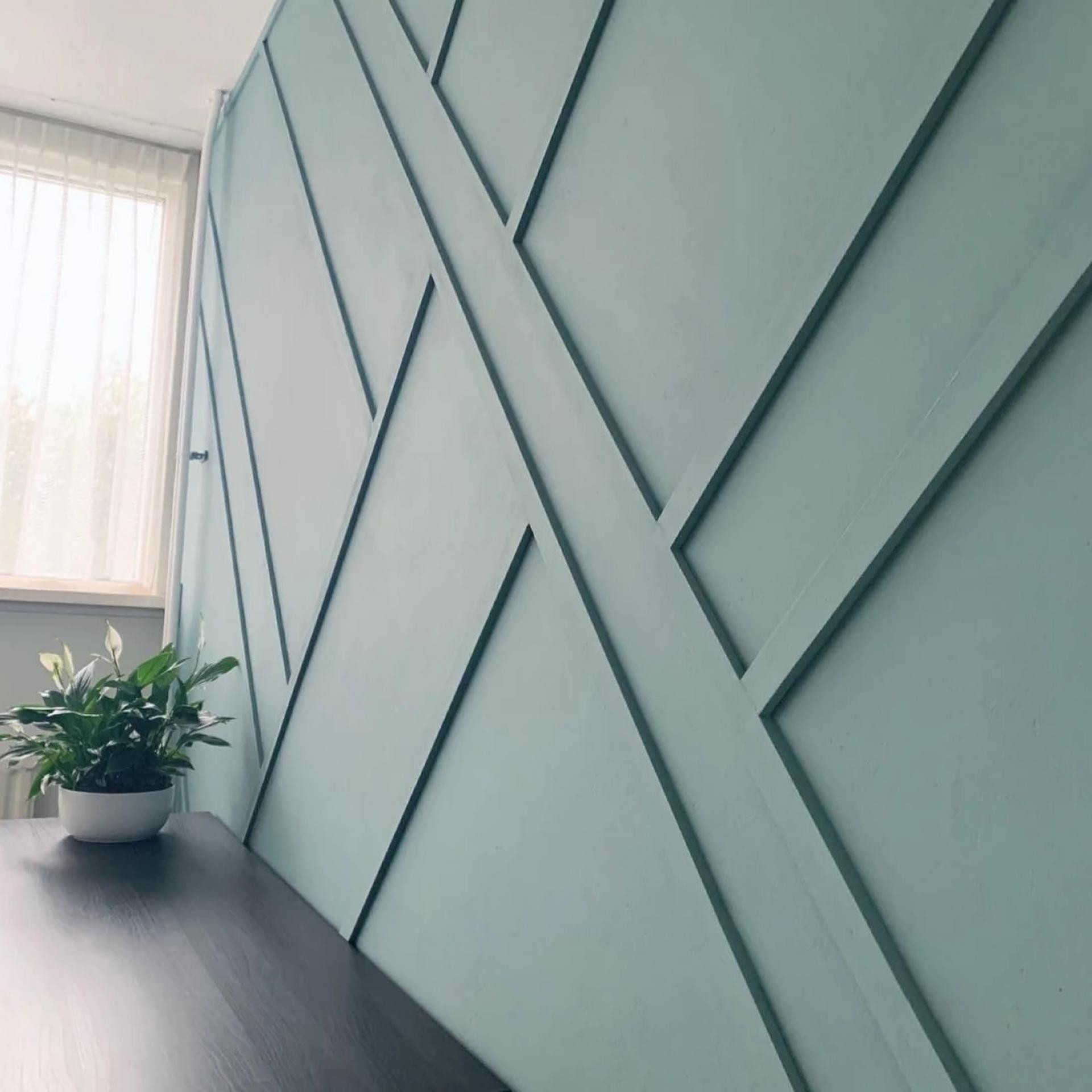 P851350 poliüretan duvar çıtası ile uygulanmış yeşil boyalı geometrik salon duvar dekorasyonu örneği.