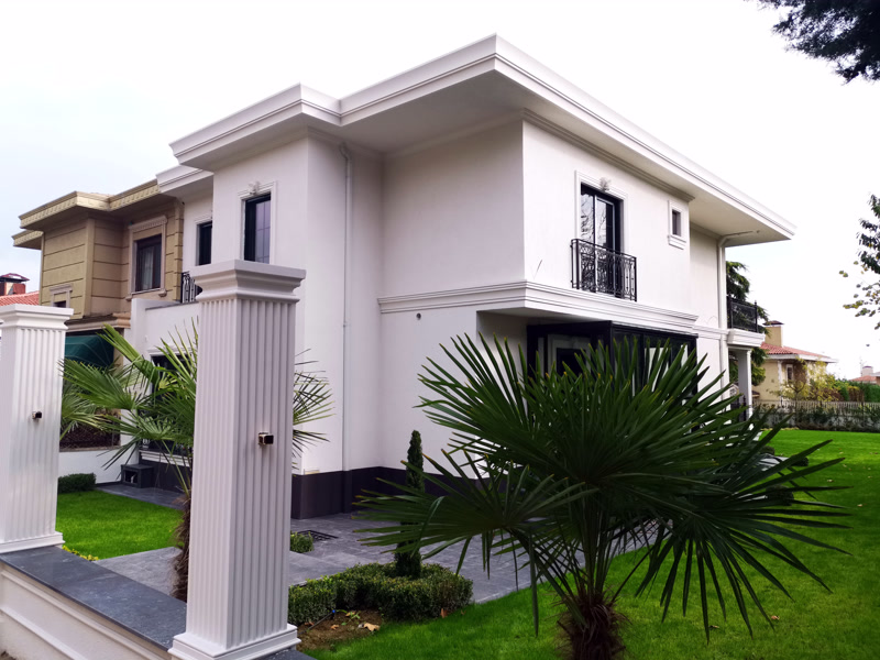 Beyaz villa dış cephesinde kullanılan poliüretan pencere söveleri ve bahçe girişinde yivli pilaster sütun modeli.