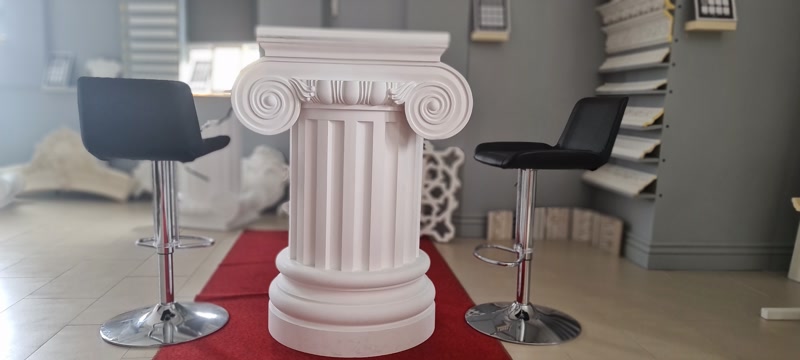 Kırmızı halı üstünde duran beyaz poliüretan iyonik sütun, P5250I başlık ve P5850 yivli gövde sergileme modeli.