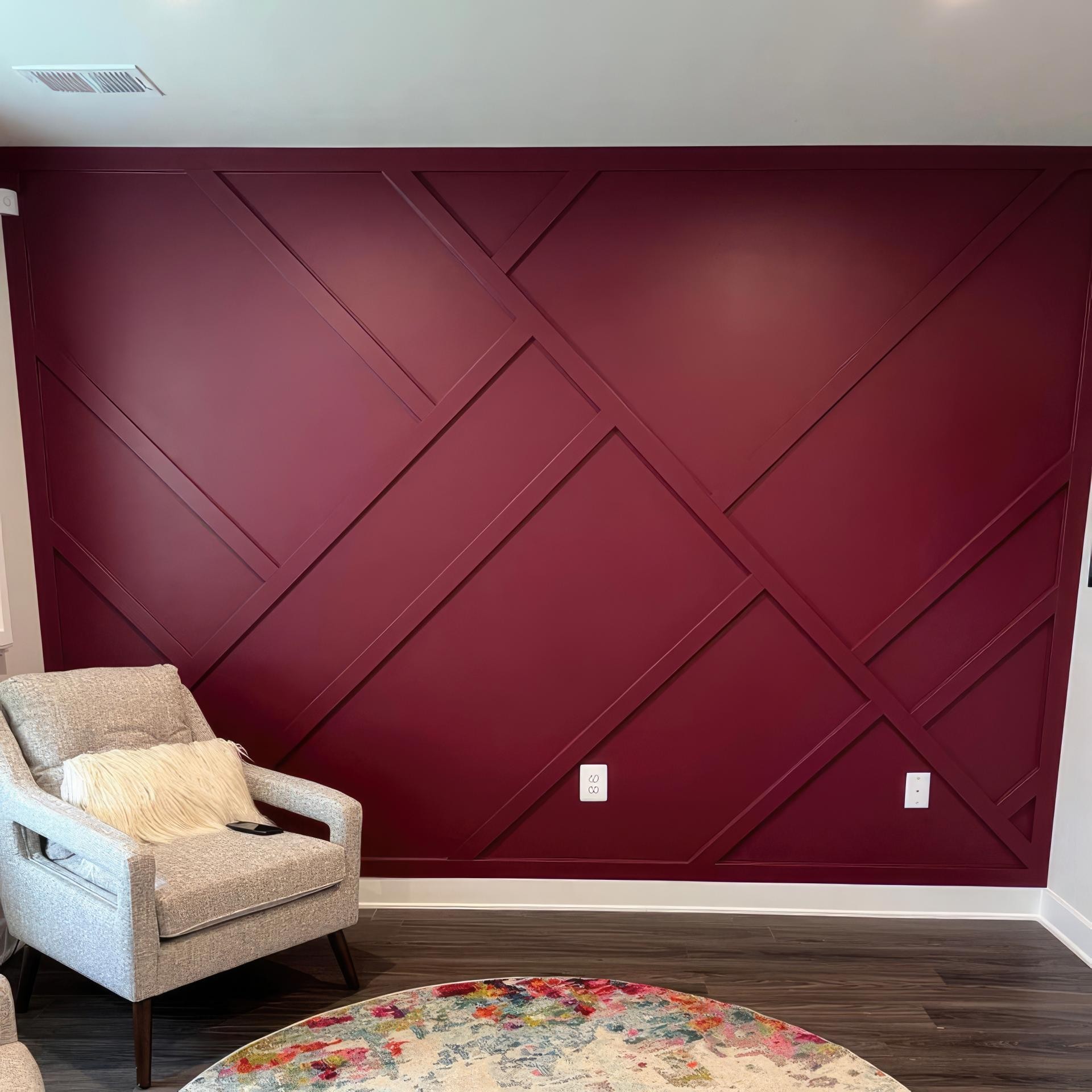 Bordo renkli salonda P851350 poliüretan duvar çıtaları ile uygulanmış geometrik baklava desenli modern duvar dekoru.