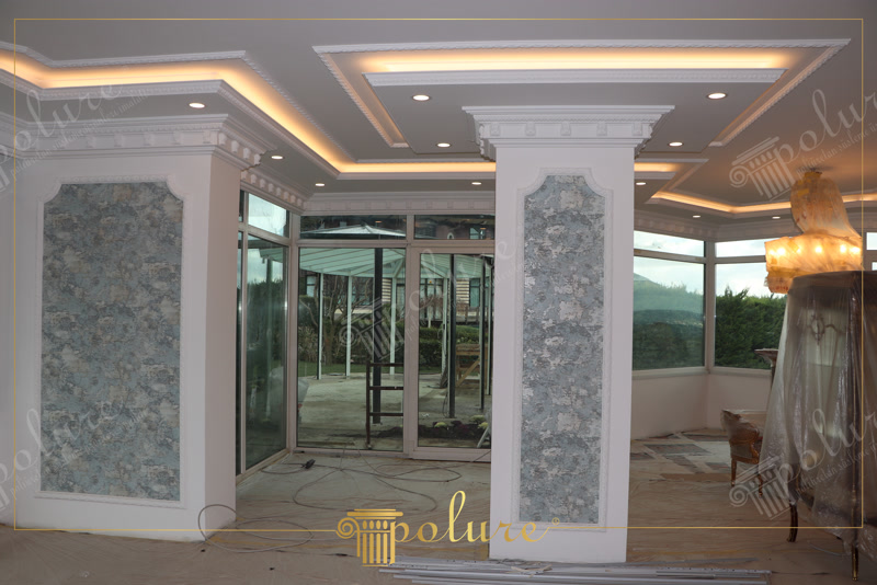 Poliüretan gizli ışıklı tavan kornişleri ve desenli kolon çıta kaplaması yapılan modern klasik salon tasarımı.