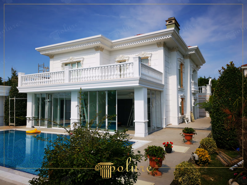 Poliüretan söve, pilaster sütun ve balustrad kaplamalı beyaz neoklasik villa dış cephesi ve havuz alanı.