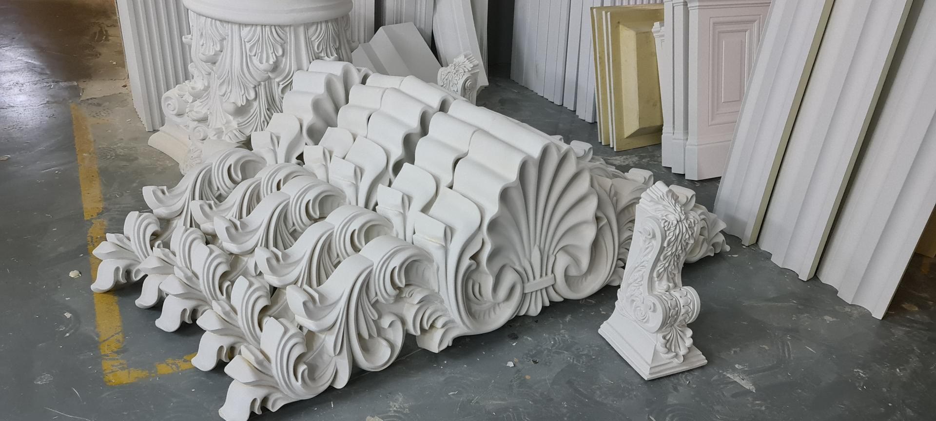 Fabrika alanında üst üste istiflenmiş kabartmalı poliüretan dış cephe kapı ve pencere taç modelleri P2838.