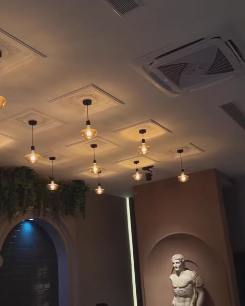 Geometrik tavan çıtaları ve kemerli nişlerle tasarlanan salon