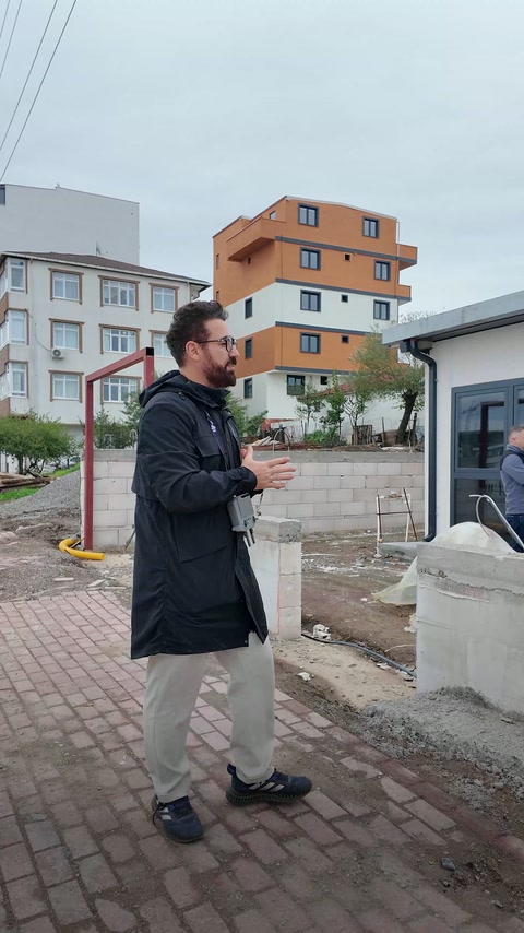 Uzman bina cephesi önünde saha ölçüm sürecini açıklıyor