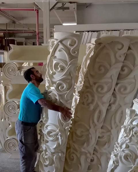 Atölyede yan yana dizilmiş büyük oymalı dekoratif sütun ayakları