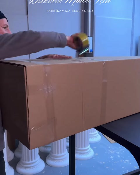 Paketlenen poliüretan dekor parçalarının bulunduğu karton kutu kapatılıyor