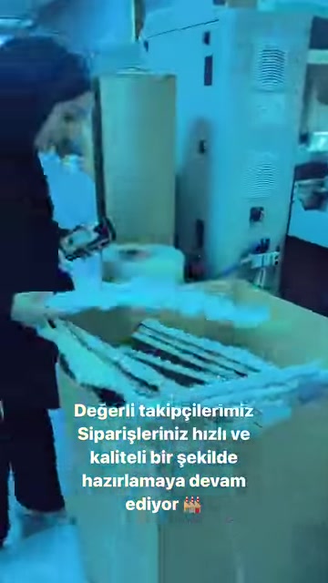 Tezgâhtaki uzun beyaz dekoratif parçalar çalışan tarafından inceleniyor.