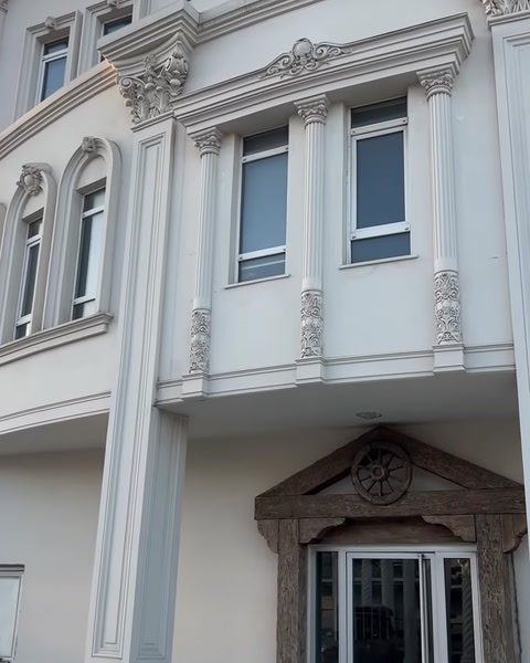 Villa cephesinde pencereler arasında kullanılan işlemeli dekoratif sütunlar
