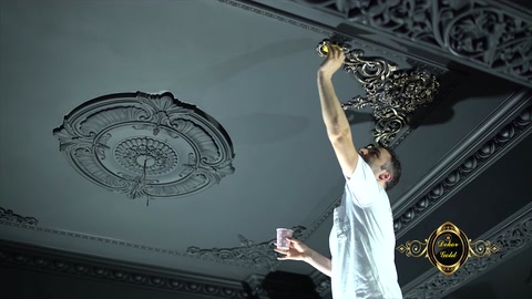 Tavan kartonpiyerindeki kabartmalar uzun fırçayla altın renge boyanıyor