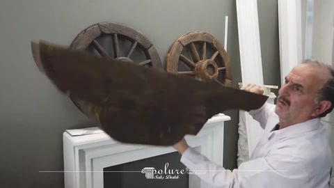 Usta, poliüretan kütük modelini yakından inceleyerek taşıyor