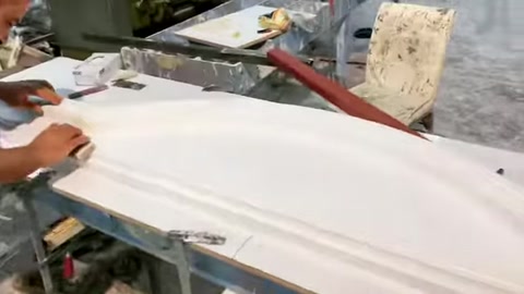 Usta, tezgâhtaki uzun pencere sövesi profilinin yüzeyini düzenliyor.