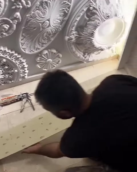 Usta, yapıştırıcı sürülen paneli zeminden kaldırmaya hazırlanıyor