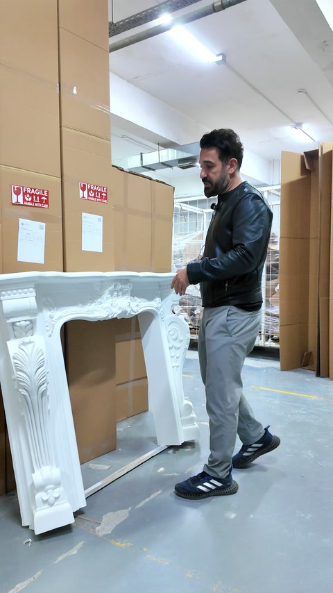 Beyaz şömine çerçevesinin süslü yan elemanları paketleme bölümünde görülüyor
