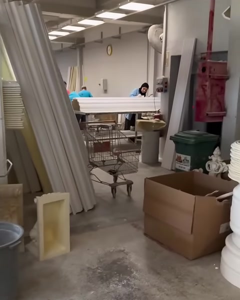 Üretim atölyesinde uzun profiller, çalışma masaları ve ekipmanlar görülüyor.