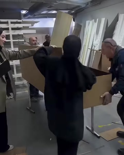 Çalışanlar uzun ürün kutusunun karton kapaklarını düzenliyor