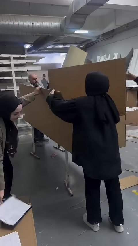 Dolu ürün kutusunun geniş karton kapağı kapatılmaya hazırlanıyor