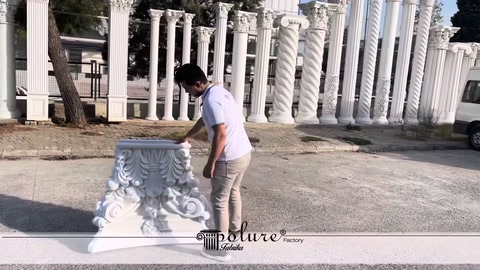 Görevli yerdeki işlemeli beyaz sütun başlığını inceliyor