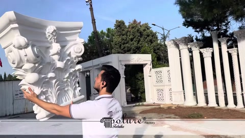 Görevli büyük desenli sütun başlığını dış mekânda tutuyor
