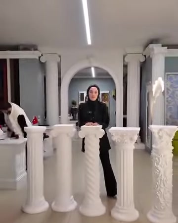Çeşitli yüksekliklerde beyaz dekoratif sütunlar showroom boyunca diziliyor