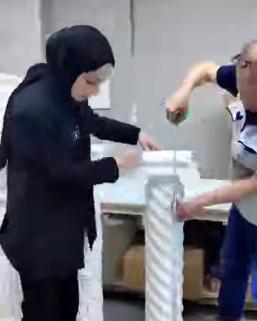 Çalışanlar burgulu sütun sehpa üzerinde birlikte işlem yapıyor