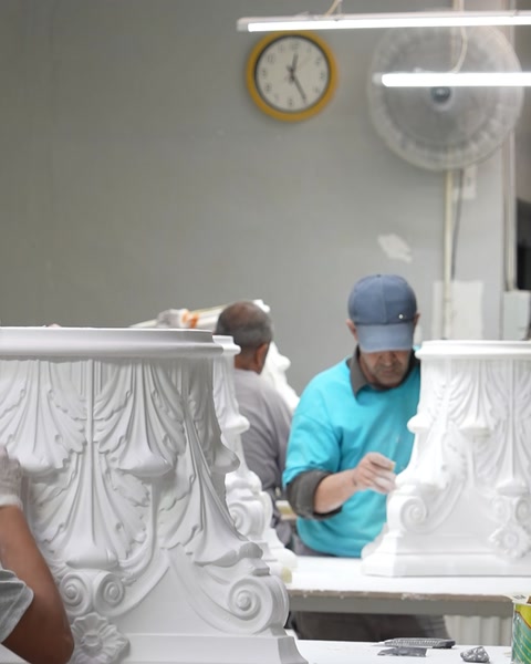 İki usta tezgâhta korint başlıklı sütun detayını cilalıyor
