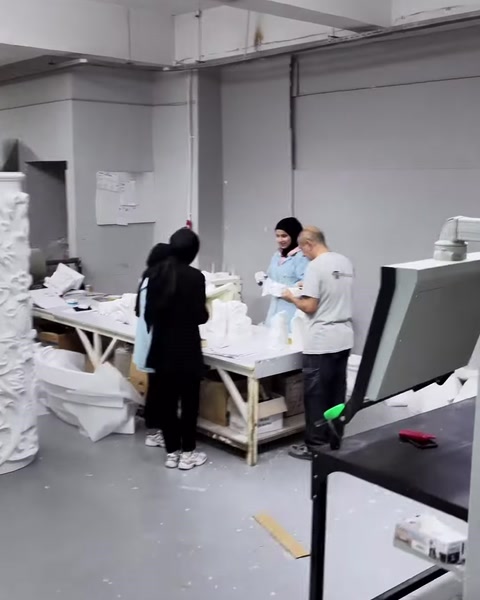 Çalışanlar beyaz dekoratif parçaları paketleme öncesinde kontrol ediyor.