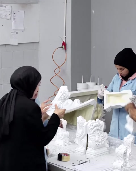 Dekoratif sütun başlığı parçasının yüzeyi elle dikkatle inceleniyor.