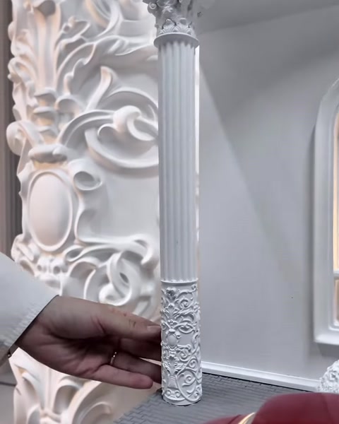 Sütun gövdesindeki yoğun bitkisel kabartma detayları yakından gösteriliyor.