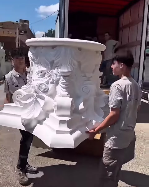 Dekoratif sütun başlığı geniş üst tablasıyla dik konumda tutuluyor.