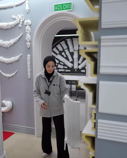 Sunucu showroom rafındaki poliüretan profil çeşitlerini inceliyor