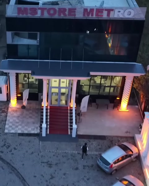 Cam kapılı bina cephesini çevreleyen aydınlatmalı sütun uygulamaları