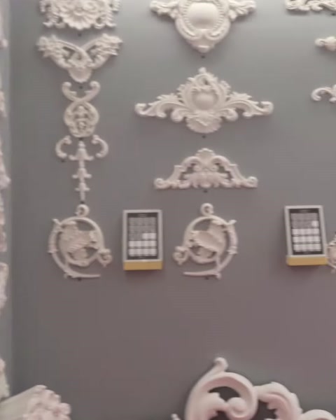 Simetrik ve sarkıt biçimli motif modelleri gri duvarda sergileniyor