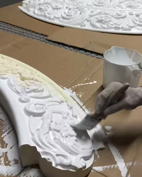 Kabartma desenli çerçeve yüzeyi fırçayla özenle kaplanıyor
