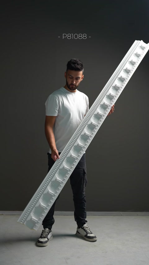 Tekrarlayan geometrik kabartmalı kartonpiyer modeli elde gösteriliyor.