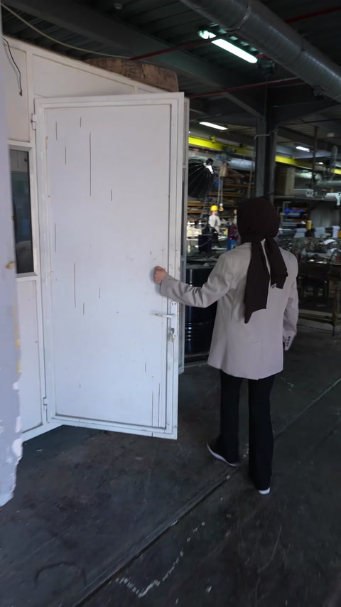 Çalışan büyük beyaz pencere modülünü atölye içinde taşıyor