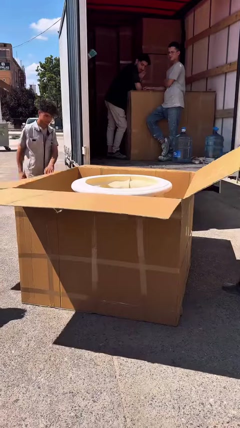Büyük karton kutu açılarak beyaz sütun başlığı ortaya çıkarılıyor
