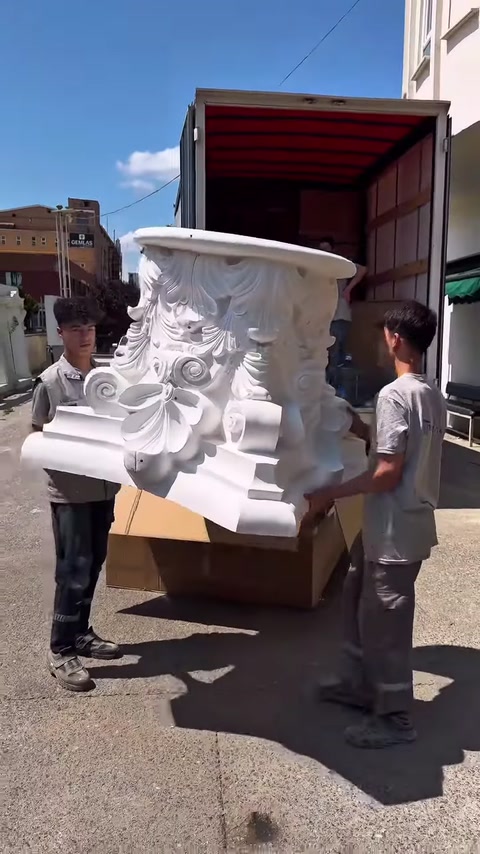 Büyük dekoratif başlık iki kişi tarafından kontrollü biçimde taşınıyor