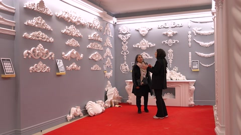 Showroom duvarında geniş süsleme ve kartonpiyer koleksiyonu gezilirken