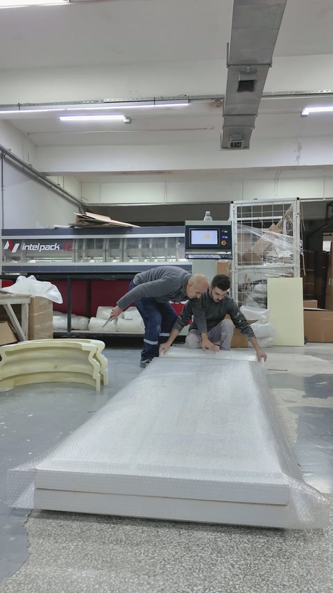 İki çalışan uzun panel çerçevesini tezgâhta birleştiriyor.
