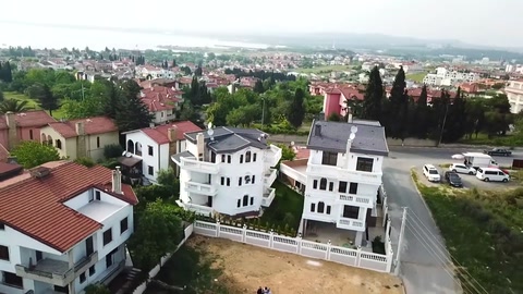Konutlar arasındaki villa yerleşimi ve beyaz cephe karakteri görülüyor.