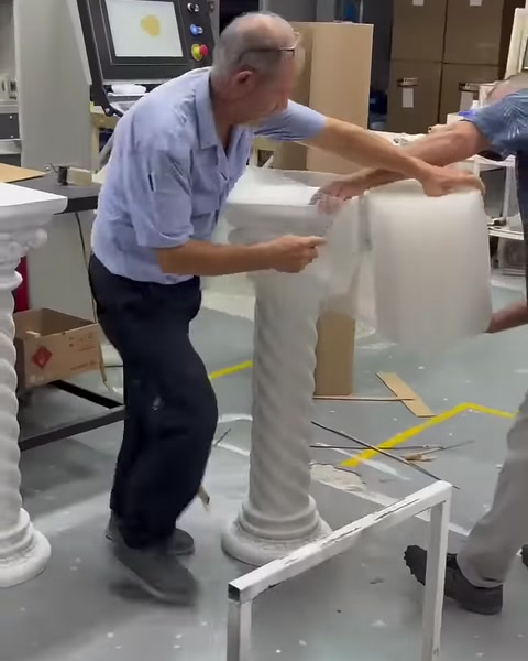 Sehpa sütununun üst tablası koruyucu malzemeyle sarılıyor