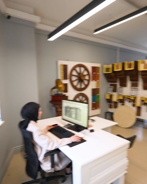 Ofis duvarındaki dekoratif tekerlek süslemesi önünden geçiliyor