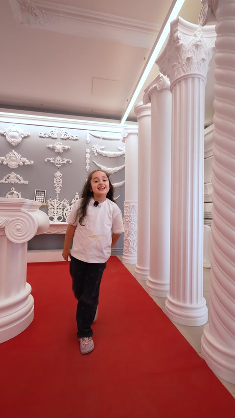Sütunlar ve duvar süsleriyle düzenlenmiş showroom koridoru görülüyor.