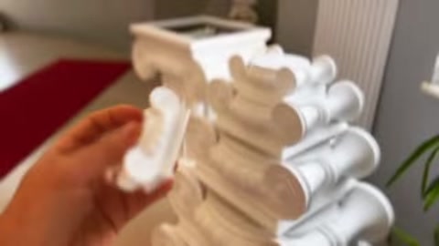Mikro ölçekli sütun başlığı modeli parmaklar arasında yakından inceleniyor