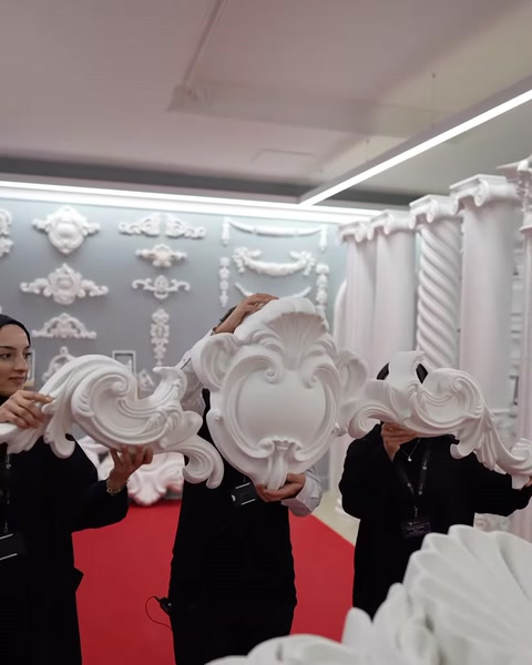 Oval merkezli, yoğun kıvrım süslemeli pediment modeli elde tutuluyor.