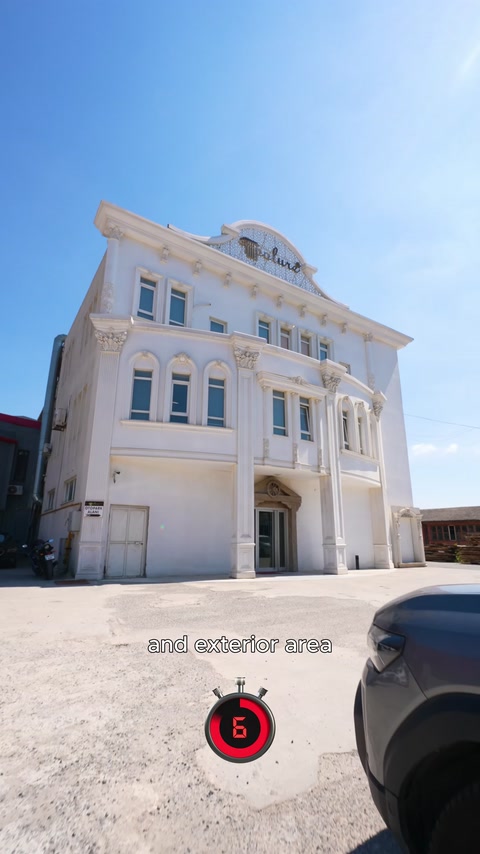 Beyaz binada pencere söveleri, sütunlar ve çatı silmeleri görülüyor